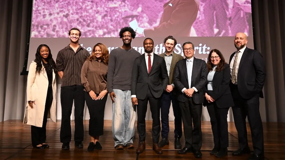 Group of people posing together on a stage with an image of Martin Luther King Junior in the background.